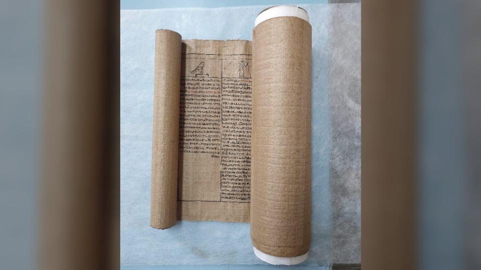 The Book of the Dead scroll slightly unrolled on a table
