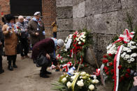 Holocaust survivors and former Auschwitz inmates attend a wreath lying ceremony in front of the Death Wall in the former Nazi German concentration and extermination camp Auschwitz during ceremonies marking the 78th anniversary of the liberation of the camp in Oswiecim, Poland, Friday, Jan. 27, 2023. (AP Photo/Michal Dyjuk)