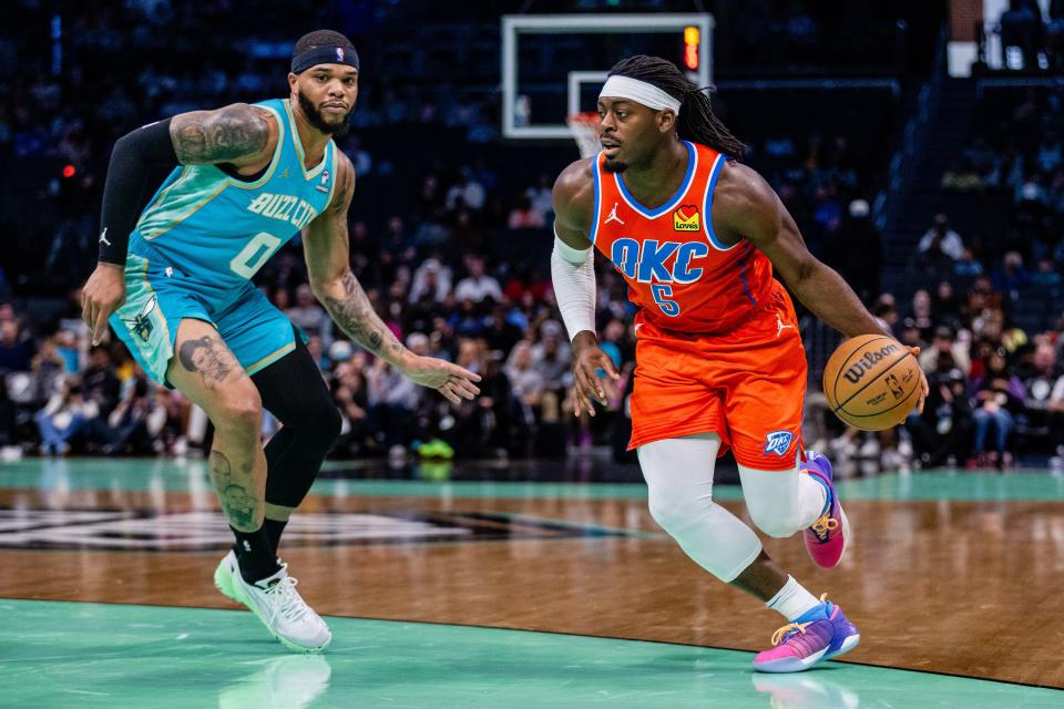 Oklahoma City's Lu Dort, right, drives past Charlotte's Miles Bridges during a game on April 7 at Spectrum Center in Charlotte, N.C.