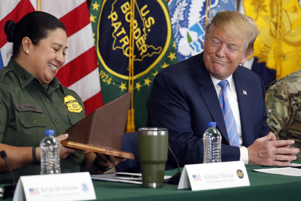 President Donald Trump receives a gift from Gloria Chavez with U.S. Customs and Border Protection at a roundtable on immigration and border security at the U.S. Border Patrol Calexico Station in Calexico, Calif., Friday April 5, 2019. Trump headed to the border with Mexico to make a renewed push for border security as a central campaign issue for his 2020 re-election. (AP Photo/Jacquelyn Martin)