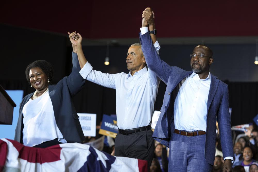 Former President Barack Obama, center, stands with Georgia gubernatorial candidate Stacey Abrams and candidate for U.S. Senate, Sen. Raphael Warnock D-Ga., during a campaign rally Friday, Oct. 28, 2022, in College Park, Ga. (AP Photo/John Bazemore)