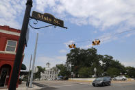 In this Aug. 5, 2019, photo, a vehicle makes its' way through an intersection in the town square in Mount Vernon, Texas. Former NBA player Greg Ostertag and his wife Shannon have spearheaded the town's recent revitalization from what used to be boarded-up buildings. The small East Texas community is also where Art Briles is coaching football again. (AP Photo/Tony Gutierrez)