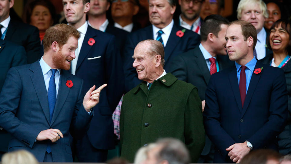 Prince William and Prince Harry standing with Prince Philip