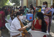 People get inoculated agains the coronavirus in Hyderabad, India, Thursday, Oct. 21, 2021. India has administered 1 billion doses of COVID-19 vaccine, passing a milestone for the South Asian country where the delta variant fueled its first crushing surge this year. (AP Photo/Mahesh Kumar A.)
