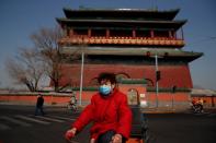 People wear face masks in a street after the novel coronavirus outbreak in Beijing