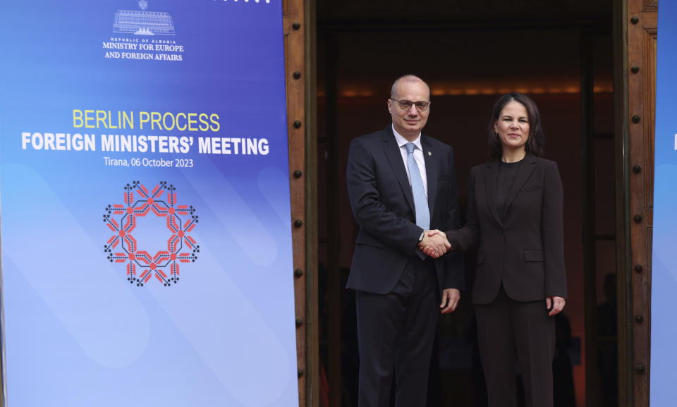 Albanian Foreign Minister Igli Hasani, left, welcomes his German counterpart Annalena Baerbock ahead of a summit in Tirana, Albania, Friday, Oct. 6, 2023. Foreign Ministers of the Western Balkans and the European Union member countries in the Berlin process, trying to raise up regional cooperation in their march toward becoming block members in the future, convene in Tirana to prepare the summit which is held in a non-EU member country. (AP Photo/Franc Zhurda)