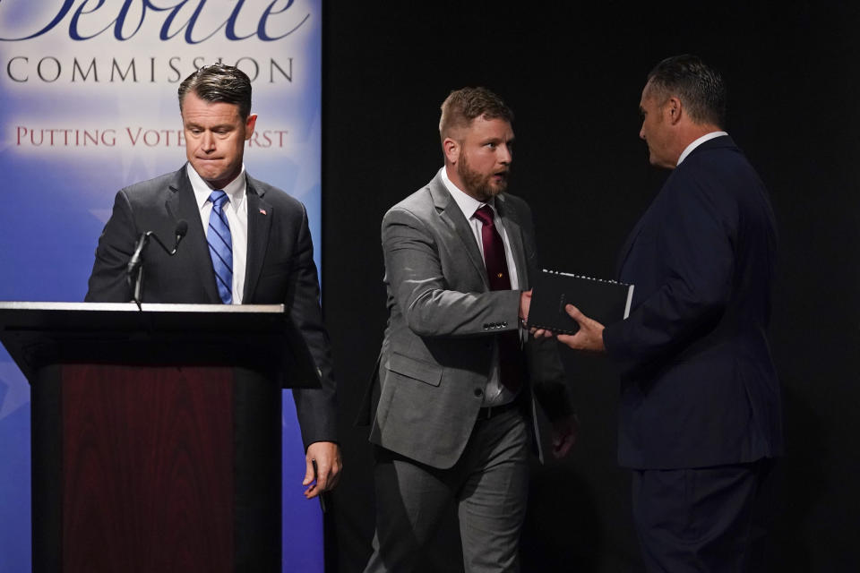 Democrat Thomas McDermott, right, shakes hands with Libertarian James Sceniak as Sen. Todd Young looks on as following a U.S. Senate debate, Sunday, Oct. 16, 2022, in Indianapolis. (AP Photo/Darron Cummings, Pool)