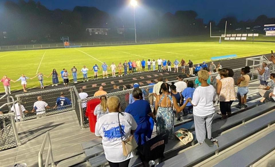 Attendees at a memorial service for former Harrodsburg High School football coach Alvis Johnson held hands in prayer Sunday after many shared memories about the Kentucky coaching legend at Alvis Johnson Field in Harrodsburg.