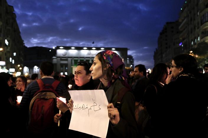 A woman holds a paper with Arabic that reads, "hold your martyr high," during a candle light vigil for victims of a Sunday bombing at a Coptic cathedral, in downtown Cairo, Egypt, Wednesday, Dec. 14, 2016. Twenty five Christians were killed at the city's main Coptic cathedral in what was one of the deadliest attacks on the religious minority in recent memory. The bomb went off while worshippers were attending Sunday Mass at a chapel adjacent to St. Mark's Cathedral. (AP Photo/Nariman El-Mofty)