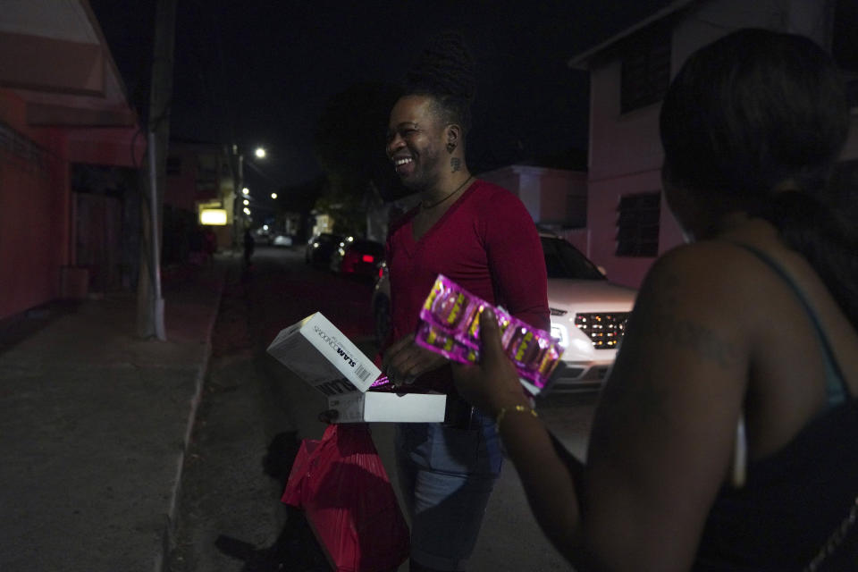 Orden David voluntarily distributes condoms to sex workers in St. John's, Antigua, early Saturday, May 13, 2023. (AP Photo/Jessie Wardarski)