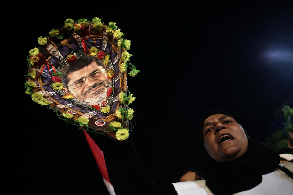 A supporter of Egypt's ousted President Mohammed Morsi chants slogans against Egyptian Defense Minister Gen. Abdel-Fattah el-Sissi and holds a basket with pictures of Morsi at Rabaah al-Adawiya mosque, where supporters of Egypt's ousted President Mohammed Morsi have installed a camp and hold daily rallies at Nasr City, in Cairo, Egypt, Thursday, Aug. 1, 2013. (AP Photo/Hassan Ammar)