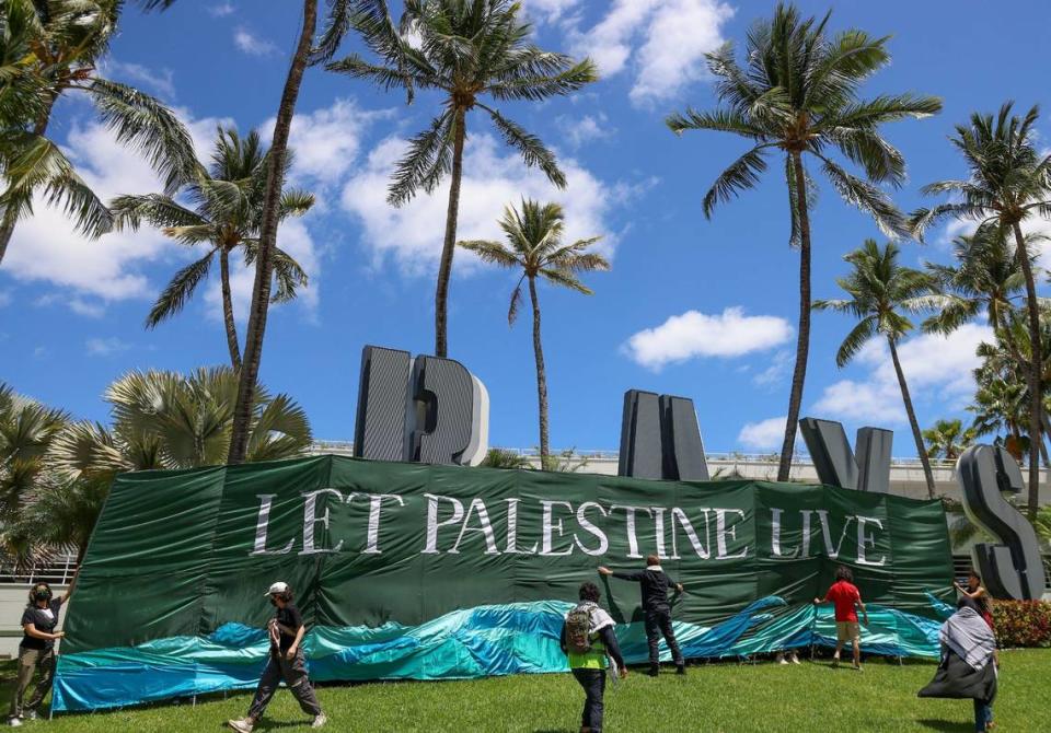 A group protesting for ceasefire in support of Gaza stopped to unveil a banner as they marched towards Bayside in downtown Miami Monday, April 15, 2024. Carl Juste/cjuste@miamiherald.com