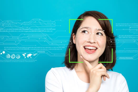 An illustration of facial recognition technology being used on a woman. Her face is surrounded by green lines, while other lines outline the features of her face.