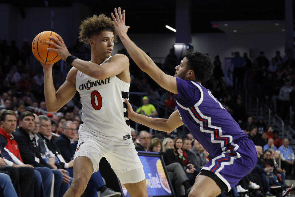 Cincinnati's Dan Skillings, left, looks for an open pass as TCU's Trevian Tennyson defends during the first half of an NCAA college basketball game Tuesday, Jan. 16, 2024, in Cincinnati. (AP Photo/Jay LaPrete)