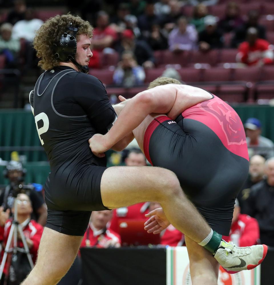 Aidan Fockler of Perry, left, grabs the leg of Aaron Ries of Wadsworth during their 285-pound Division I state championship match, Sunday, March 12, 2023, in Columbus.