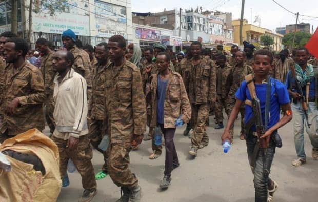 Tigrayan fighters escort captured Ethiopian soldiers to a detention camp after retaking the Tigrayan capital of Mekelle on July 2. (Reuters - image credit)