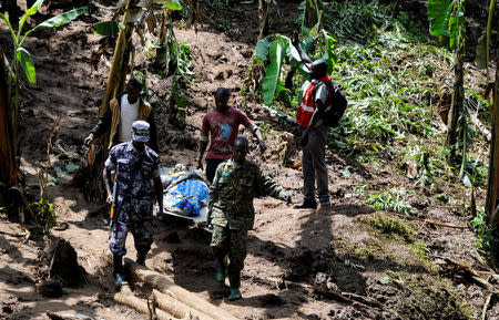 Security officers and residents carry an injured survivor rescued after a landslide rolled down the slopes of Mt. Elgon through their Nanyinza village in Bududa district, Uganda October 13, 2018. REUTERS/Stringer
