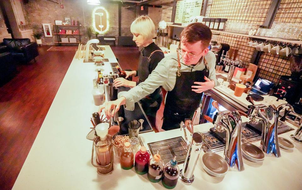 Olivia Molter, left, and Ryan Castelaz assemble an order for 12 coffees during the soft opening Saturday of Discourse Coffee's flagship cafe on Broadway.