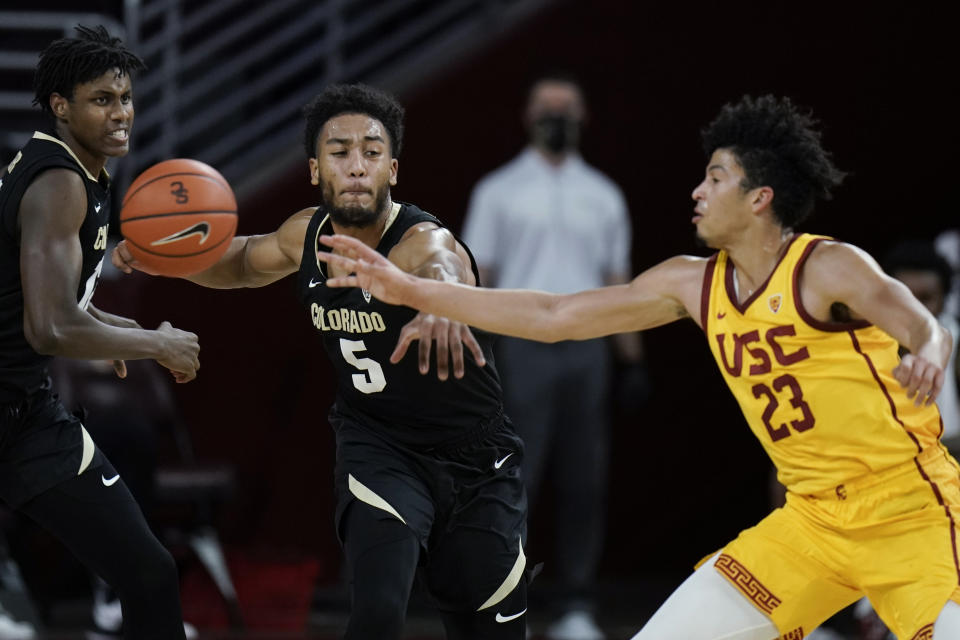 Colorado's D'Shawn Schwartz, left, tries to steal the ball from Southern California's Max Agbonkpolo during the first half of an NCAA college basketball game Thursday, Dec. 31, 2020, in Los Angeles. (AP Photo/Jae C. Hong)