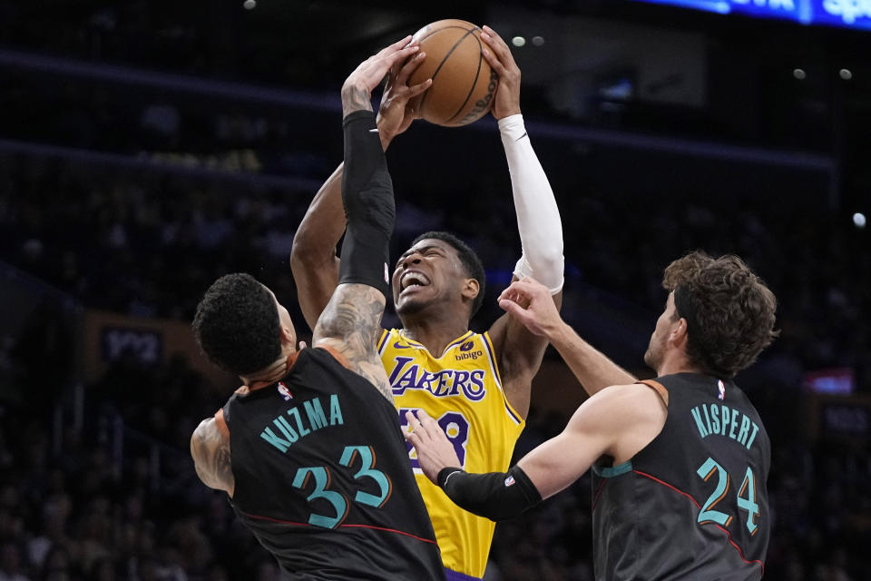 Los Angeles Lakers forward Rui Hachimura, center, shoots as Washington Wizards forward Kyle Kuzma, left, and forward Corey Kispert defend during the first half of an NBA basketball game Thursday, Feb. 29, 2024, in Los Angeles. (AP Photo/Mark J. Terrill)