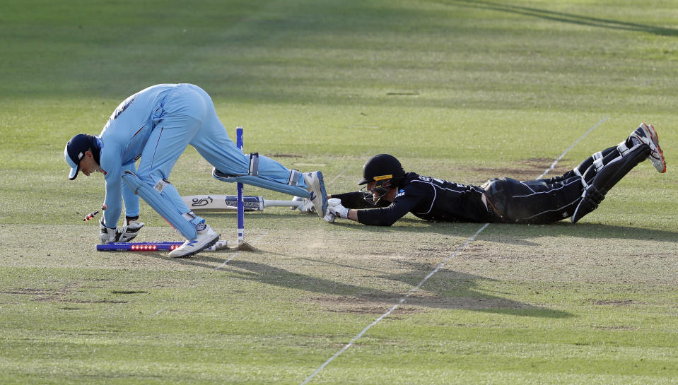 England's Jos Buttler runs out New Zealand's Martin Guptill to win the Cricket World Cup final match between England and New Zealand at Lord's cricket ground in London, Sunday, July 14, 2019. England won after a super over after the scores ended tied after 50 overs each. (AP Photo/Alastair Grant)