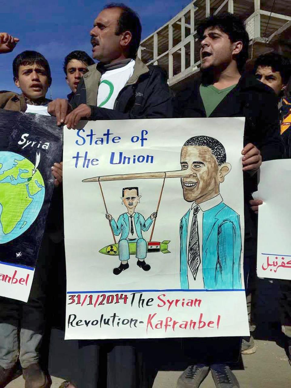 In this image provided by Edlib News Network (ENN), an anti-Bashar Assad activist group, which has been authenticated based on its contents and other AP reporting, anti-Syrian government protesters chant slogans as they hold a placard resembling U.S. President Barack Obama, right, and Syrian President Bashar Assad during a demonstration in Kafr Nabil town, Idlib province, northern Syria, Friday, Jan. 31, 2014. (AP Photo/Edlib News Network ENN)