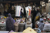 A woman buys food items at a local market in Serrekunda, Gambia, Sunday, Dec. 5, 2021, the day after Gambians came to vote in a presidential election. Election officials in the West African nation of Gambia have started counting marble votes after polls closed for the first presidential election in decades that does not include former dictator Yahya Jammeh as a candidate. (AP Photo/Leo Correa)