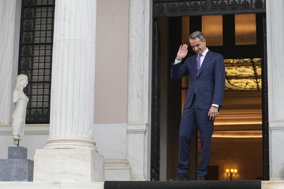 Greece's Prime Minister Kyriakos Mitsotakis waves to caretaker Prime Minister Ioannis Sarmas at the end of a handover ceremony at Maximos mansion, in Athens, Greece, Monday, June 26, 2023. Greece's conservative New Democracy party leader Kyriakos Mitsotakis has vowed to speed up reforms following his landslide victory in the country's second election in five weeks. (AP Photo/Petros Giannakouris)