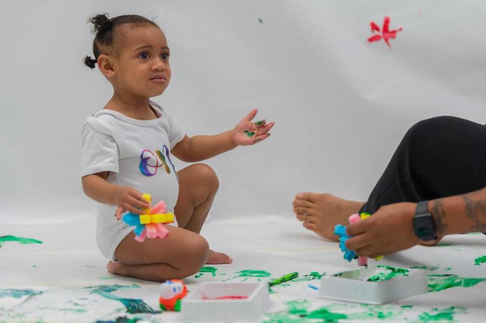 One-year-old Leilani Moananu, wasn’t so sure about having globs of paint on her hands during the baby paint crawl at Science City.