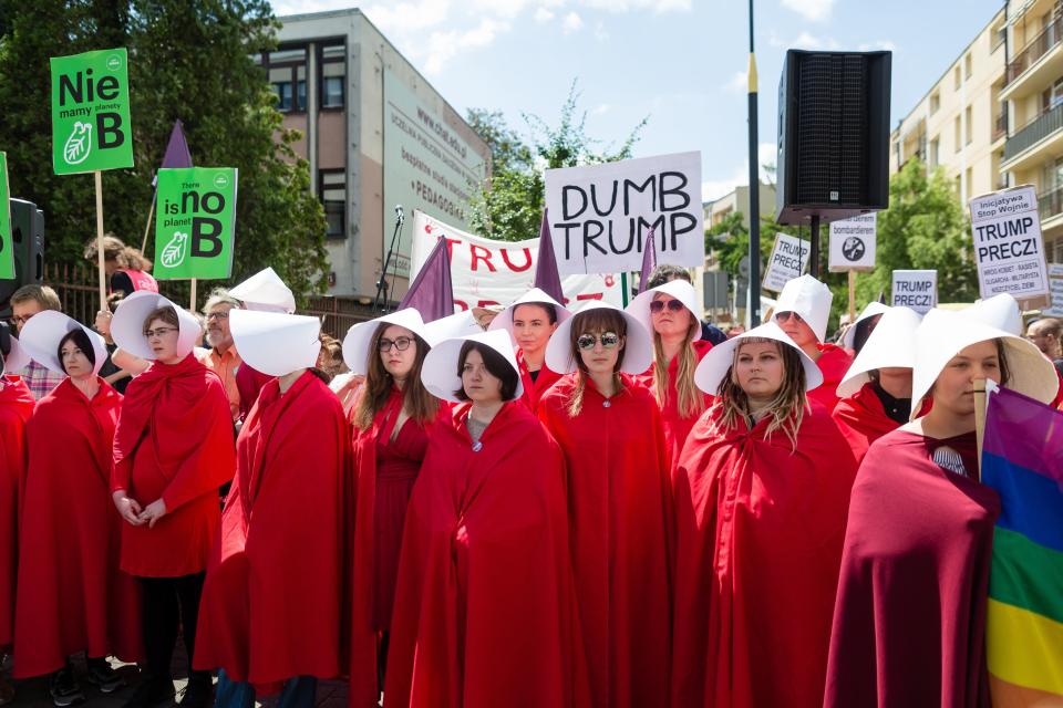 Demonstrators dressed as women from "The Handmaid's Tale" protest Trump's visit.&nbsp;