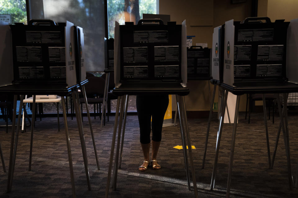 A voter casts her ballet at a vote center, Tuesday, Sept. 14, 2021, in Huntington Beach, Calif. With Gov. Gavin Newsom's fate at stake, Californians on Tuesday cast the last of the ballots that will decide whether he continues to lead them or if the nation's most populous state veers in a more conservative direction amid anger over his actions during the COVID-19 pandemic. (AP Photo/Jae C. Hong)