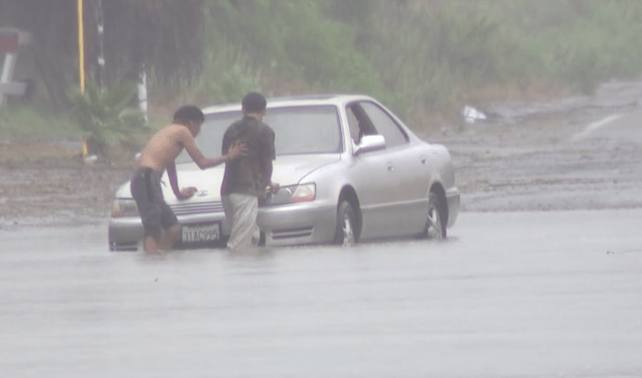 Two men try to get a car out of standing water in the Tijuana River Valley on Aug. 20, 2023. (KSWB/FOX 5)