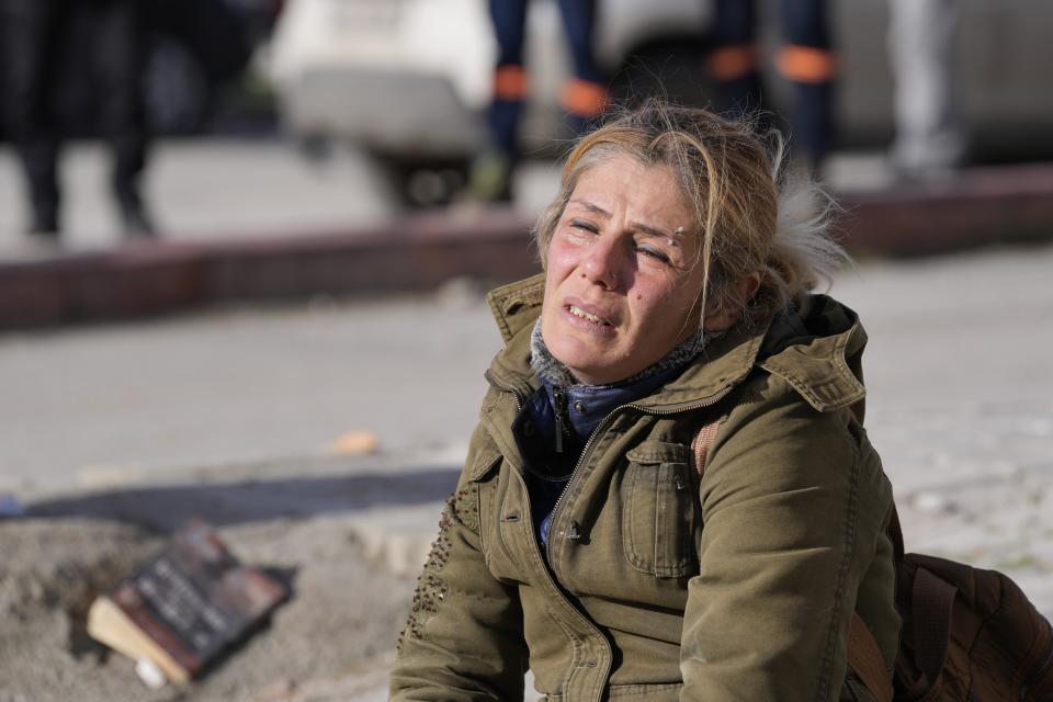 A woman cries in Iskenderun town, southern Turkey, Tuesday, Feb. 7, 2023. A powerful earthquake hit southeast Turkey and Syria early Monday, toppling hundreds of buildings and killing and injuring thousands of people. (AP Photo/Hussein Malla)