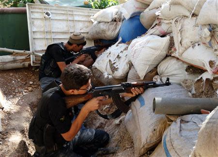 Free Syrian Army fighters take up positions behind piled sandbags as they aim their weapons in the eastern al-Ghouta, near Damascus September 8, 2013. Picture taken September 8, 2013. REUTERS/Msallam Abd Albaset