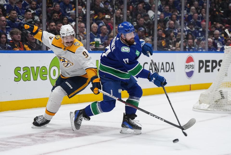 Vancouver Canucks' Filip Hronek (17) shoots the puck down the ice away from Nashville Predators' Filip Forsberg (9) during the second period in Game 1 of an NHL hockey Stanley Cup first-round playoff series, in Vancouver, on Sunday, April 21, 2024.