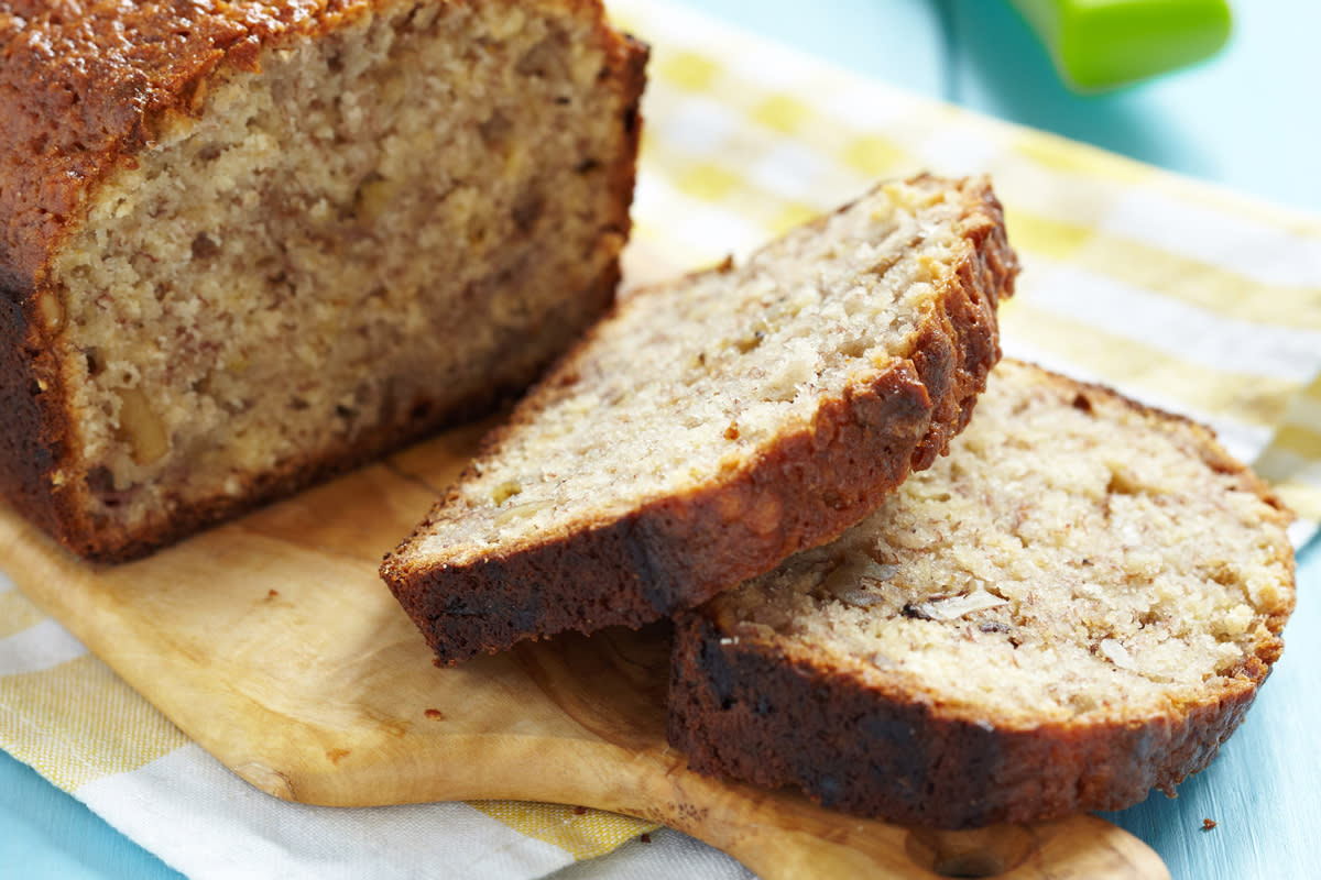 Freshly cut banana bread sits on a cutting board. 