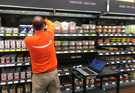 An Amazon employee manages inventory in the company's line-free Seattle store days before the store's public debut, in Seattle, Washington, U.S., January 18, 2018. Photo taken January 18, 2018. REUTERS/Jeffrey Dastin