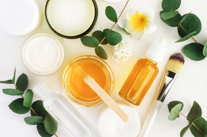 Natural skin care and cosmetics products are arranged on a white table.