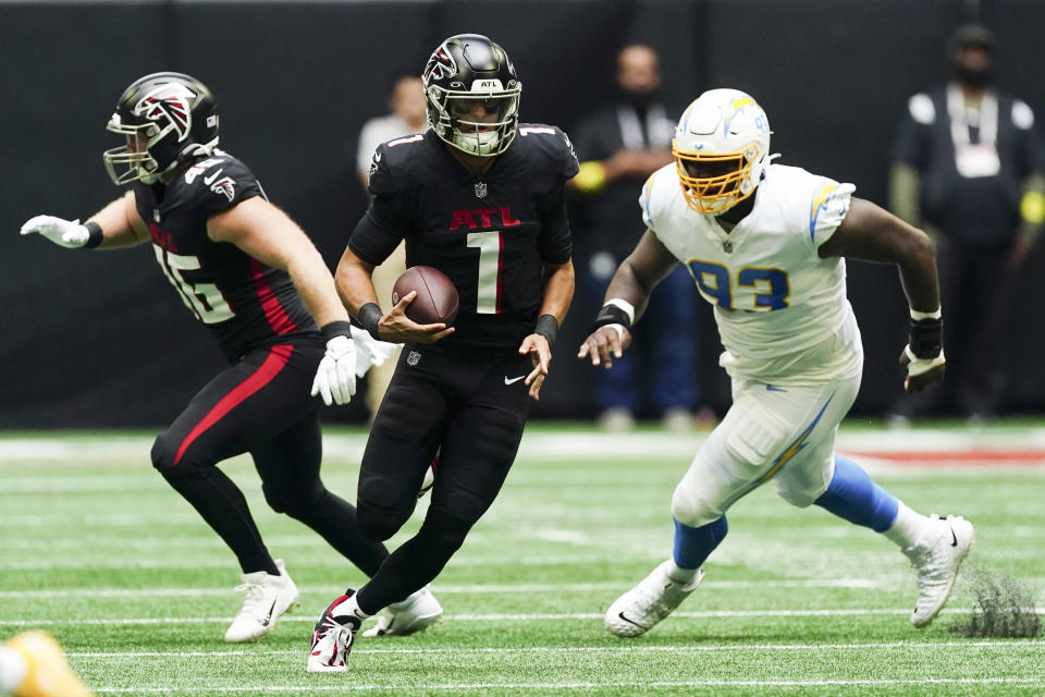 Atlanta Falcons quarterback Marcus Mariota (1) scrambles up field ahead of Los Angeles Chargers defensive tackle Otito Ogbonnia (93) during the first half of an NFL football game, Sunday, Nov. 6, 2022, in Atlanta. (AP Photo/John Bazemore)