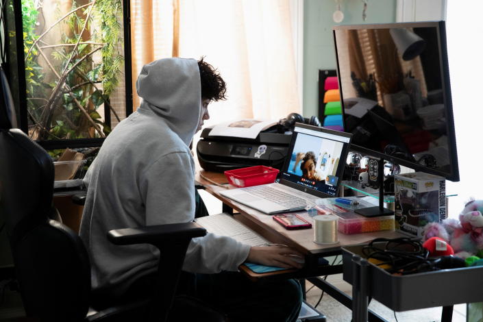 Alani Rodriguez Martinez, a ninth-grade student, sits at a desk, looking at a computer.