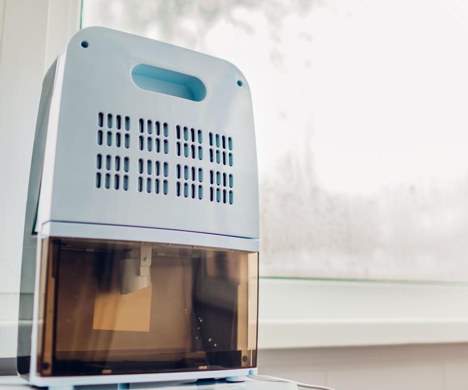 A small white dehumidifier on a windowledge