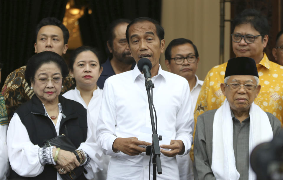 Incumbent Indonesian President Joko Widodo, center, delivers a speech as his running mate Ma'ruf Amin, right, Chairwoman of Indonesian Democratic Party-Struggle Megawati Sukarnoputri, left, and Chairman of Golkar Party Airlangga Hartarto, rear right, listen during a press conference after a coalition parties meeting in Jakarta, Indonesia, Thursday, April 18, 2019. Widodo said Thursday he was won re-election after securing an estimated 54% of the vote, backtracking on an earlier vow to wait for official results after his challenger made improbable claims of victory. (AP Photo/Achmad Ibrahim)