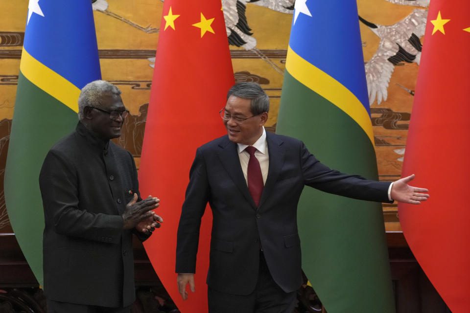 Chinese Premier Li Qiang, right, shows the way to his Solomon Islands counterpart Manasseh Sogavare after they witnessed signing on agreement for both countries at the Great Hall of the People in Beijing, Monday, July 10, 2023. (AP Photo/Andy Wong, Pool)