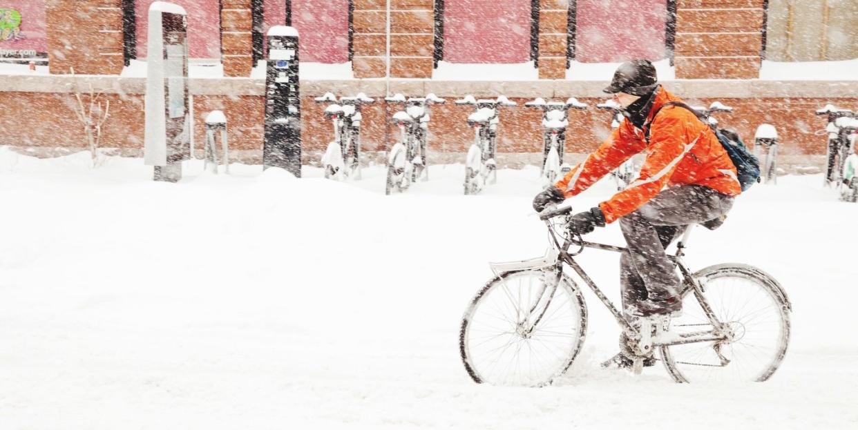 man riding bicycle on snow covered road, cycling in snow, biking on ice