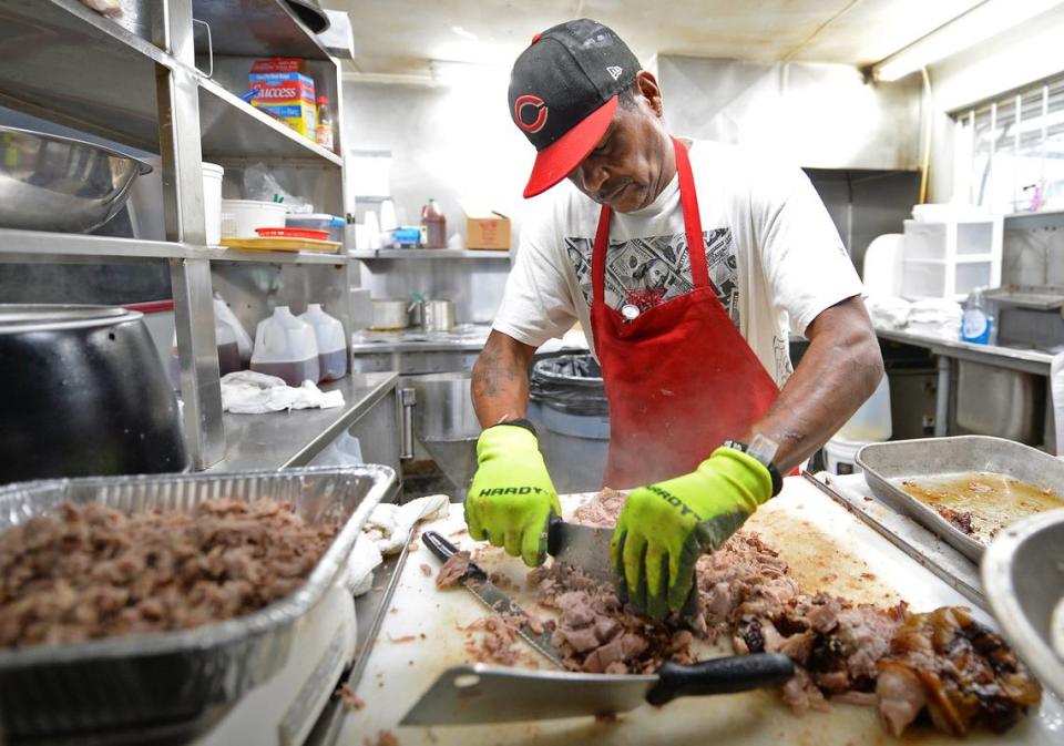 Meat cutter Charles Spikes chops up a pork shoulder at Bridges Barbecue Lodge in Shelby, NC in time for the lunch crowd on Wednesday, September 1, 2021.