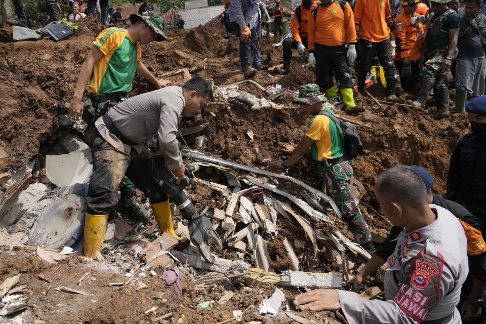 Rescuers search for the victims of an earthquake-triggered landslide in Cianjur, West Java, Indonesia, Wednesday, Nov. 23, 2022. More rescuers and volunteers were deployed Wednesday in devastated areas on Indonesia's main island of Java to search for the dead and missing from an earthquake that killed hundreds of people. (AP Photo/Tatan Syuflana)