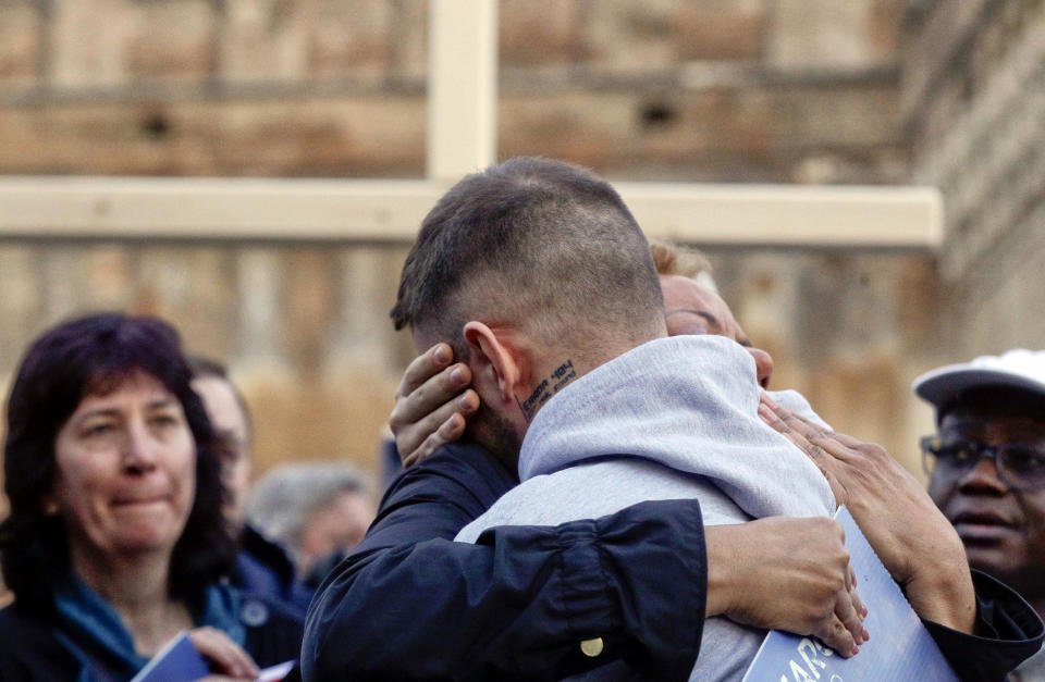 Sex abuse survivor Alessandro Battaglia, right, is hugged by survivor and founding member of the ECA (Ending Clergy Abuse), Denise Buchanan, during a twilight vigil prayer near Castle Sant' Angelo, in Rome, Thursday, Feb. 21, 2019. Pope Francis opened a landmark sex abuse prevention summit Thursday by warning senior Catholic figures that the faithful are demanding concrete action against predator priests and not just words of condemnation. (AP Photo/Gregorio Borgia)