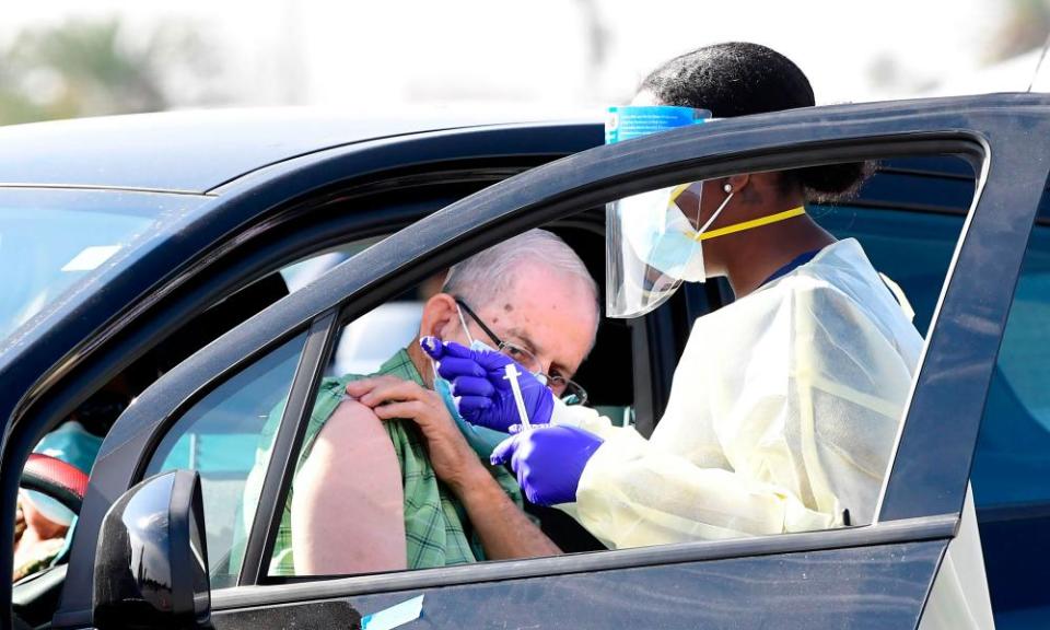 People pull up in their vehicles for Covid-19 vaccines in the parking lot of the Forum in Inglewood, California on 19 January.