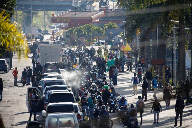 FILE PHOTO: People wait in line with their cars or motorcycles to buy gasoline, in San Atonio