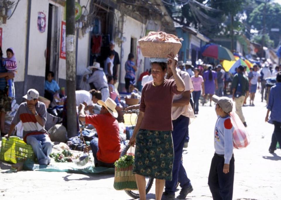 Woman and child on busy market street of Copan